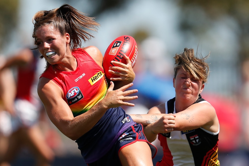 Kate Hore of the Demons grmaces while being tackled by Jayde Van Dyk of the Saints