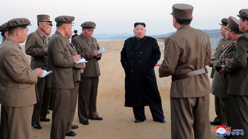 North Korean leader Kim Jong Un with defence-force personnel at a missile-testing site.