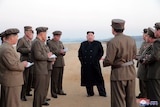 North Korean leader Kim Jong Un with defence-force personnel at a missile-testing site.