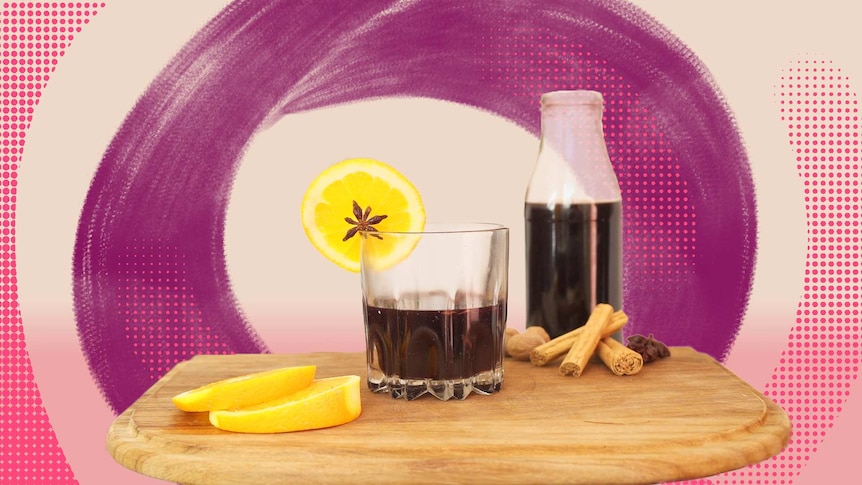 A glass of mulled wine garnished with a slice of orange and star anise, an easy alcoholic winter drink.