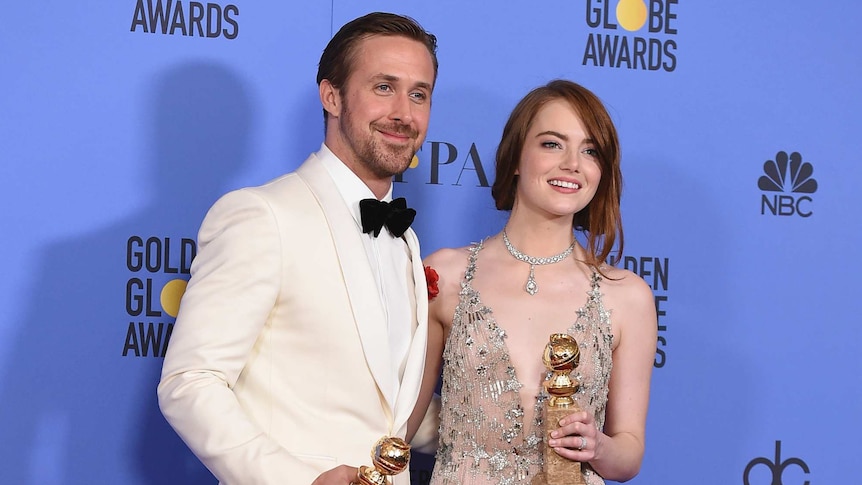 Ryan Gosling and Emma Stone pose in the press room with their Golden Globes.