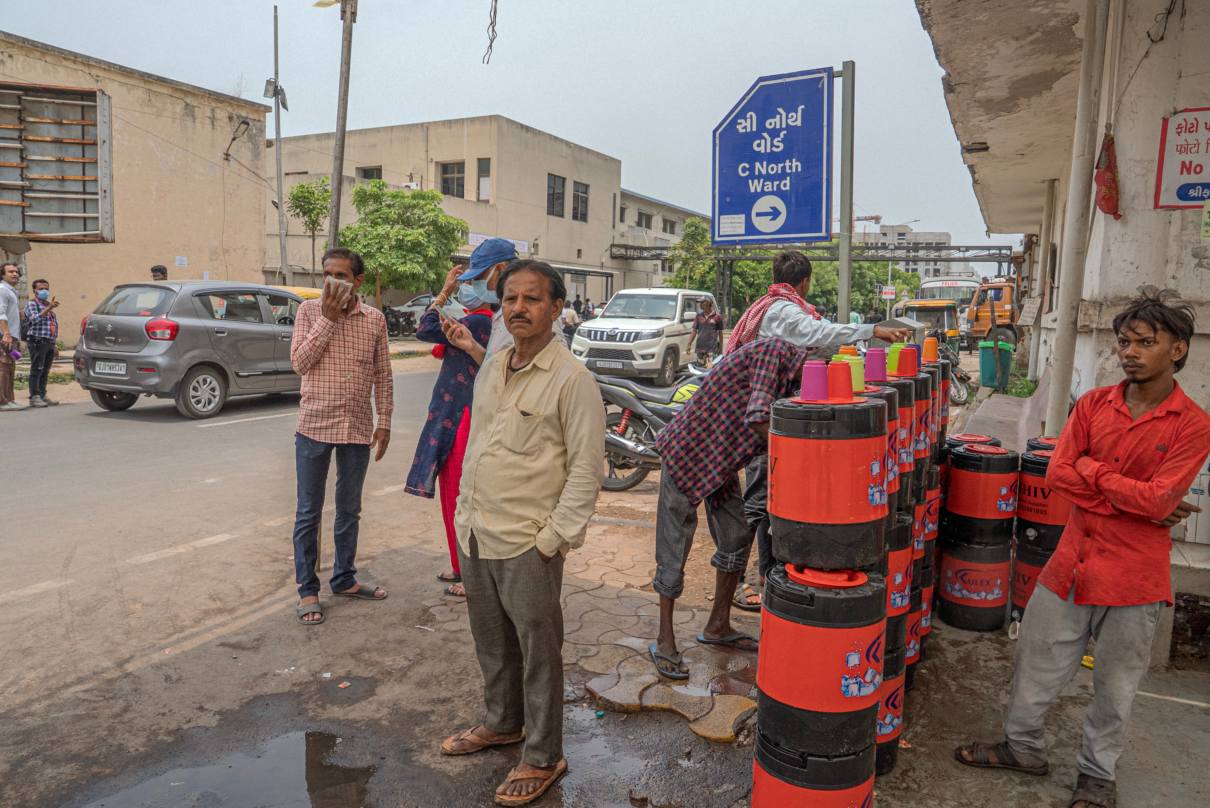 Indian man standing with other locals outside the morgue.