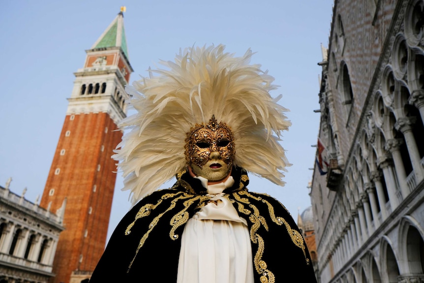 A man wearing an artisan mask poses.