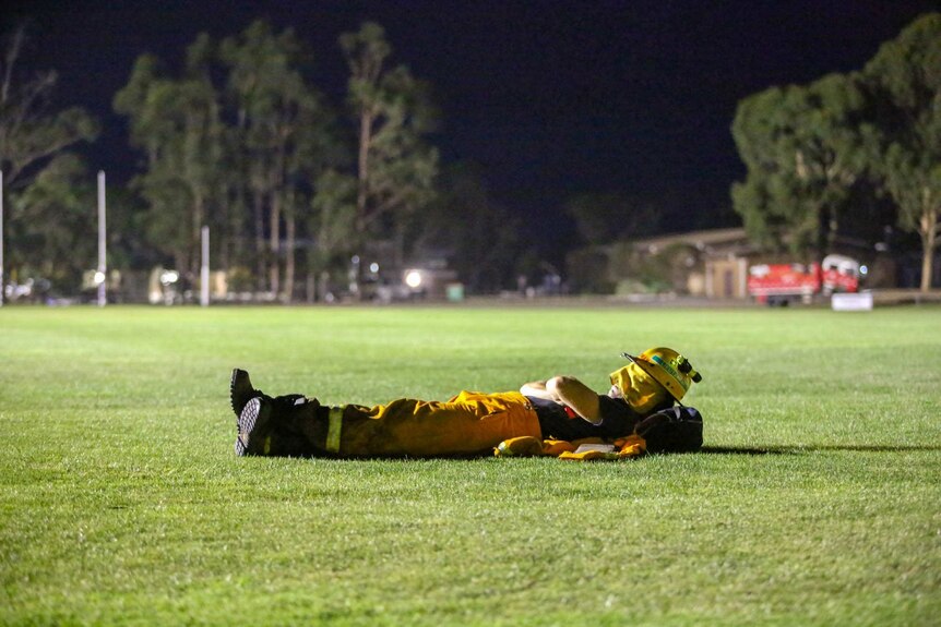 CFA volunteer sleeps on the oval at the Nar Nar Goon staging area