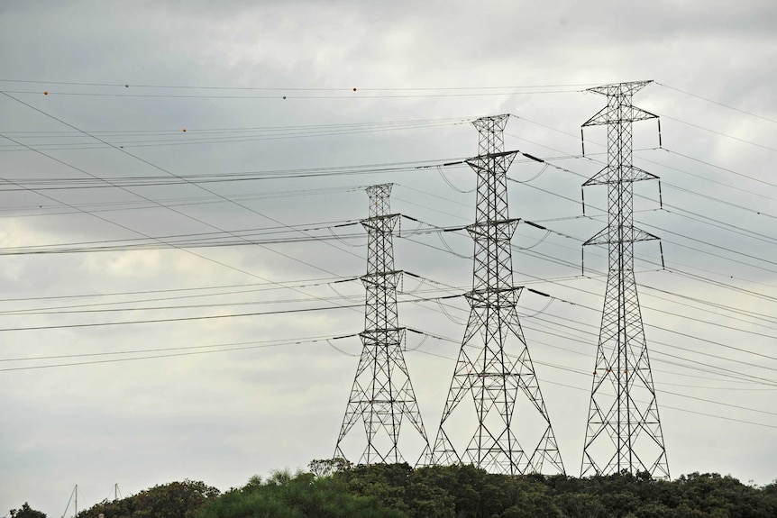 Power lines and pylons against sky.