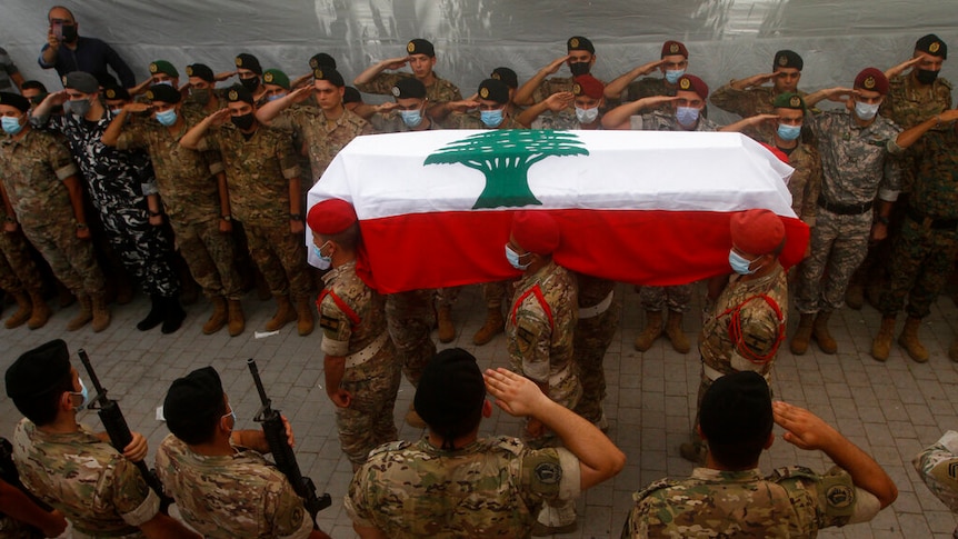 Lebanese army soldiers carry the coffin of a lieutenant who was killed by the Beirut explosion.
