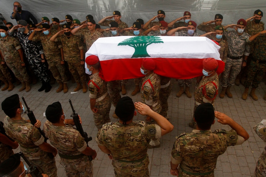 Lebanese army soldiers carry the coffin of a lieutenant who was killed by the Beirut explosion.