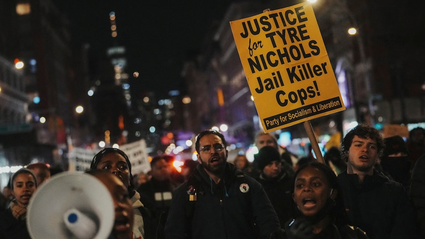 Protesters hold signs referencing the death of Tyre Nichols.