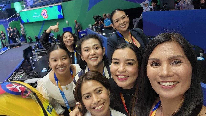 Patricia with a group of women in a basketball stadium