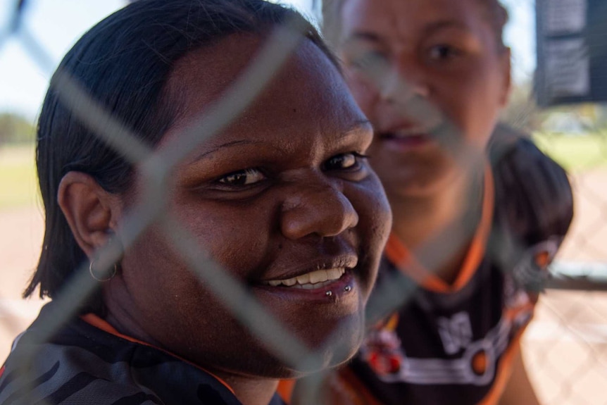 A young Indigenous woman looks at the camera.