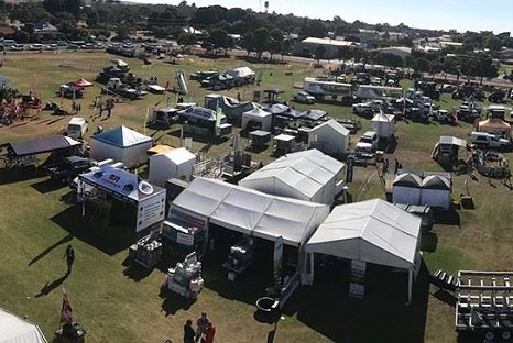 An oval filled with tents, cars and people is pictured from a bird's eye view.