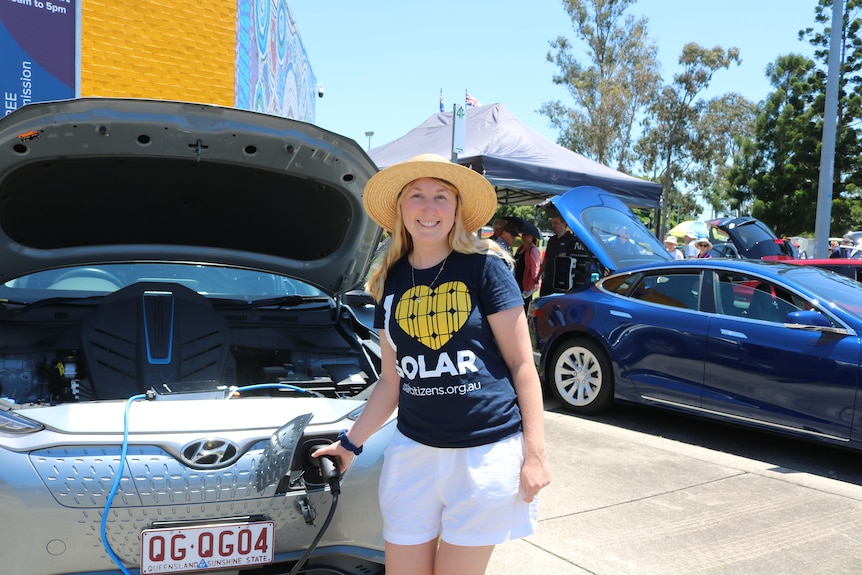 Blonde woman in car charges electric car