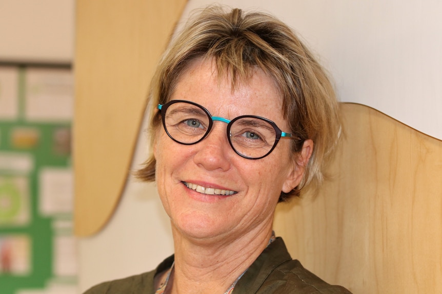 Headshot of a smiling woman wearing glasses.