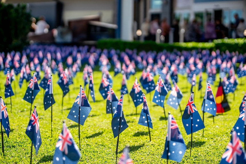 Australian and Aboriginal flags on a lawn.