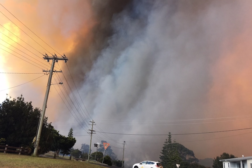 Large fire burns only meters away from a home.