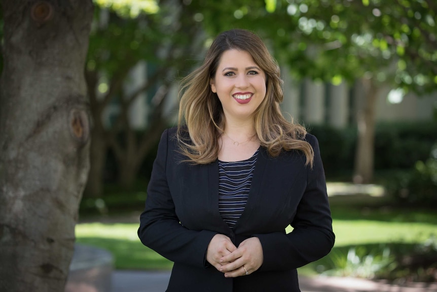 Stephanie Dalzell in the courtyard at Parliament House, smiling at the camera.