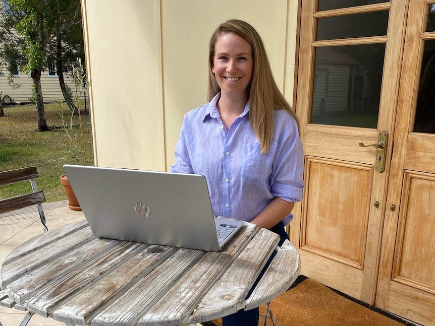 Rachel Bragg is director of Franc Paraplanning, sitting at a desk outside her home on a laptop.