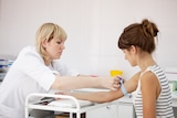 A tourniquet is applied to a woman's arm in preparation for a blood test, for a story about chickenpox and pregnancy