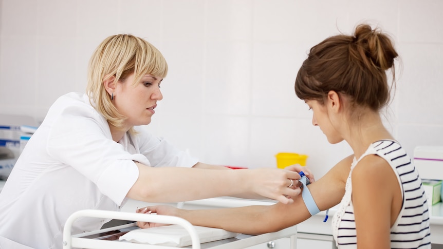 A tourniquet is applied to a woman's arm in preparation for a blood test, for a story about chickenpox and pregnancy.