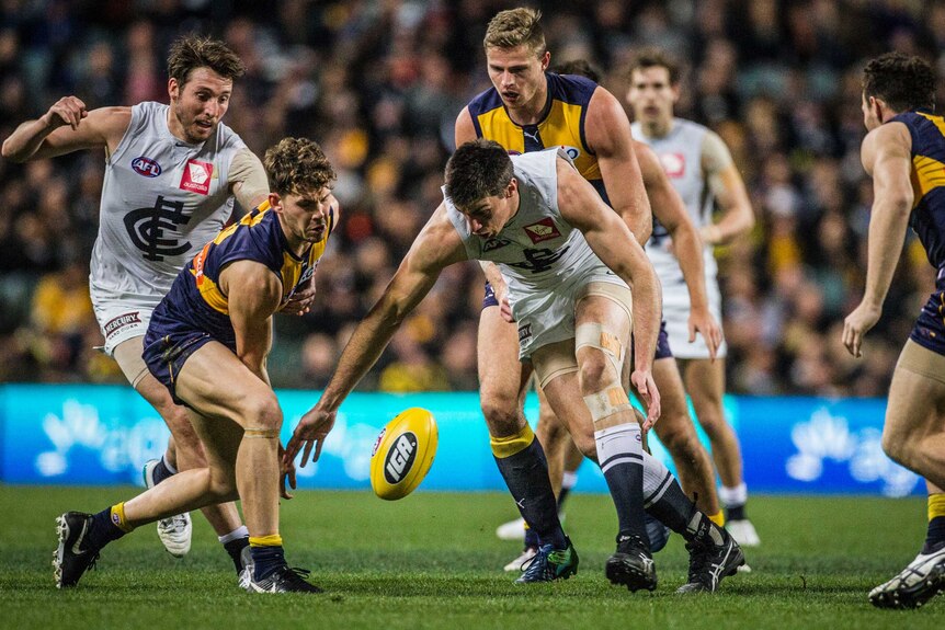 Matthew Kreuzer bends over to the contest the ball against the West Coast Eagles.
