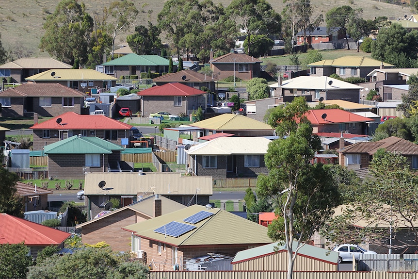 An Australian suburb with dozens of houses, many with different coloured roofs