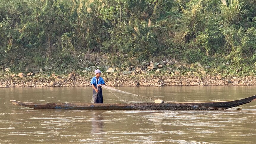 A fisherman throws out his net in the Mekong River.