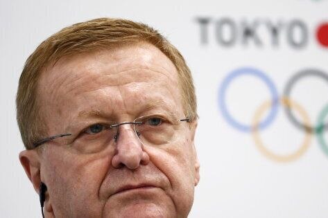 A picture of John Coates in front of a Tokyo Olympic sign