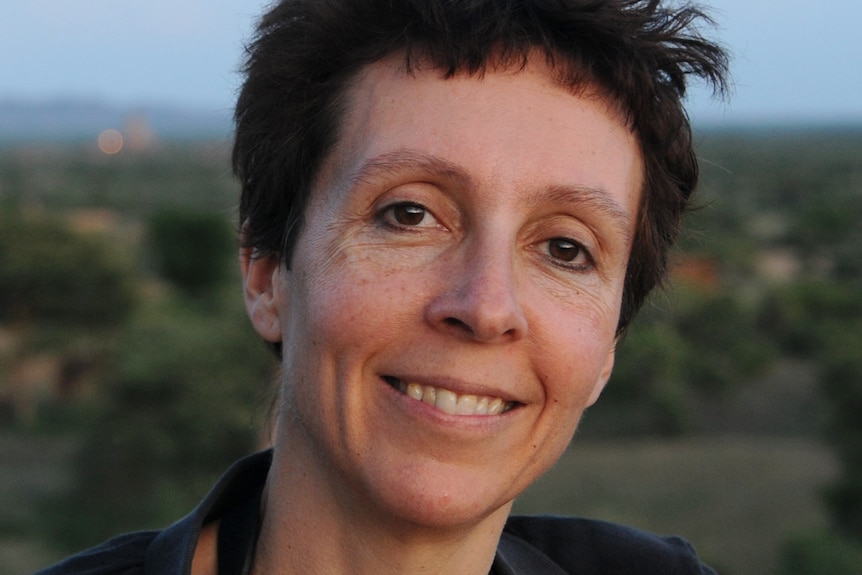 A woman with dark hair smiles at the camera. 