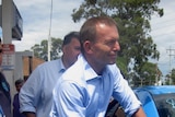 Opposition Leader Tony Abbott fills up a car with petrol at a service station in Sydney
