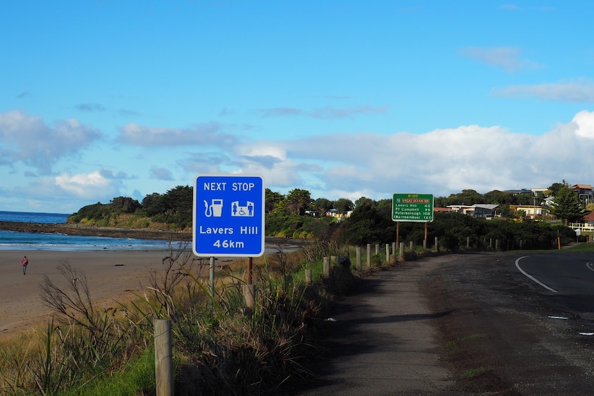 A road curves along right beside the beach.