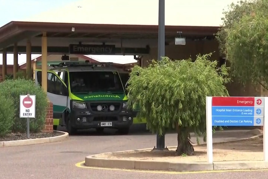 An ambulance is parked at an emergency department entrance.