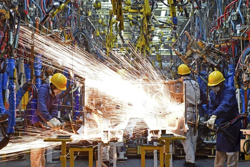 Employees work along a production line at a factory of Dongfeng Nissan Passenger Vehicle Co. in Zhengzhou, Henan province, China