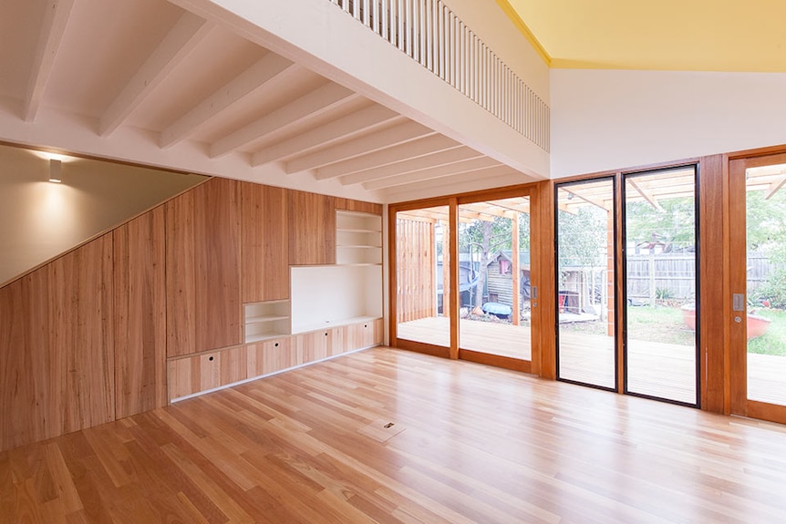 A picture of the inside of a house, with glass doors looking onto a backyard.