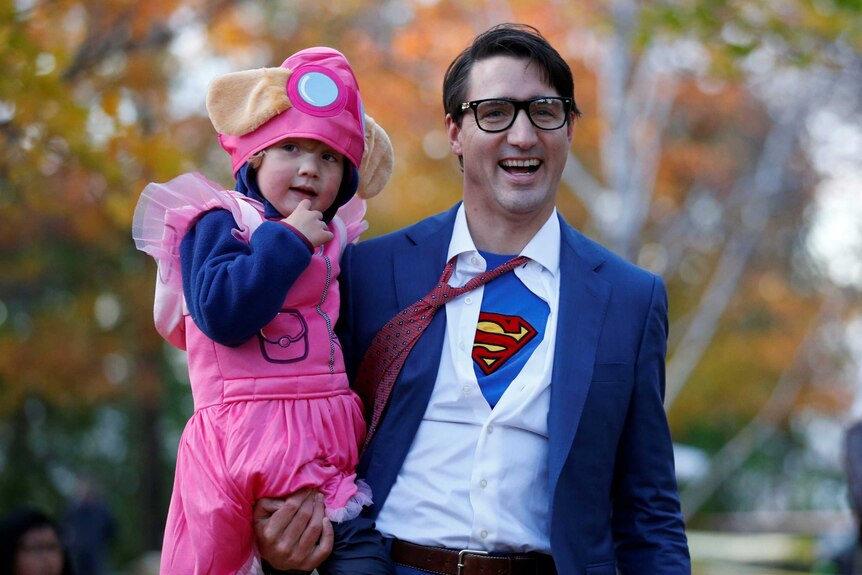 Canada's Prime Minister Justin Trudeau carries his son Hadrien while participating in Halloween festivities