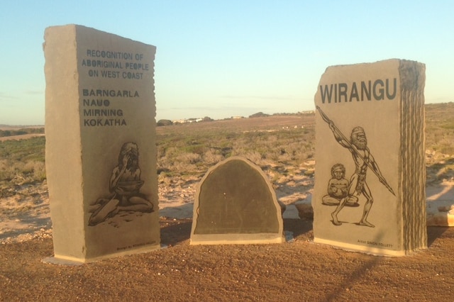 A Indigenous memorial made of stone in a desert setting.
