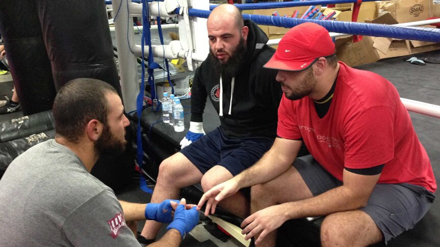 Ibrahim Nemre (L) talks to trainer Yasser (wearing black) and gym member Anas Koueider (R).