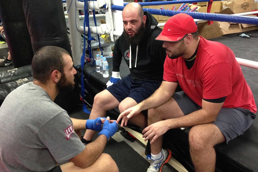 Ibrahim Nemre (L) talks to trainer Yasser (wearing black) and gym member Anas Koueider (R).