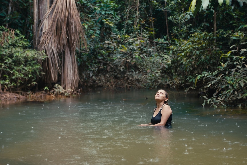 Neidinha Bandeira, an environmental activist, bathes in a river in the Amazon rainforest.