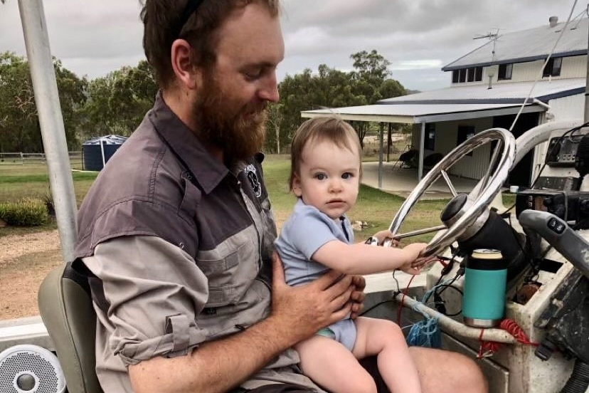 A man with a baby girl sitting in a parked boat