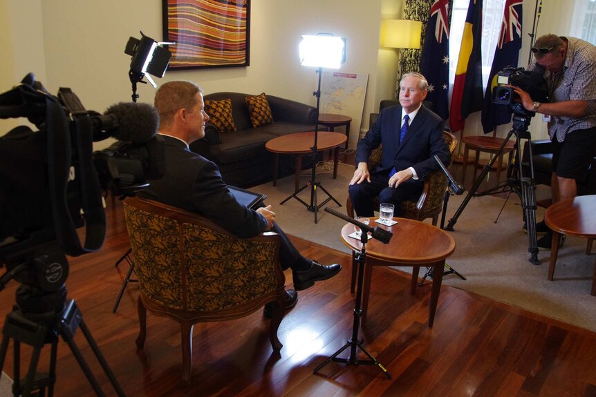 Colin Barnett sits opposite interviewer Andrew O'Connor with cameras and lights either side.