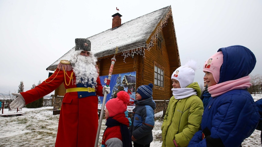 A man dressed as Father Frost, the equivalent of Santa Claus, plays with children on the eve of Catholic Christmas at the "Stalin Line" memorial near the village of Goroshki, Belarus.