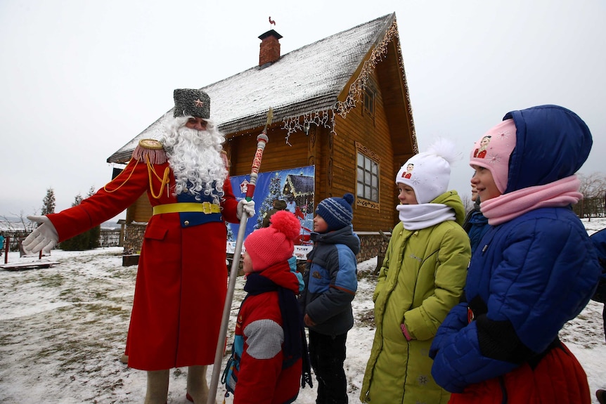A man dressed as Father Frost, the equivalent of Santa Claus, plays with children on the eve of Catholic Christmas at the "Stalin Line" memorial near the village of Goroshki, Belarus.