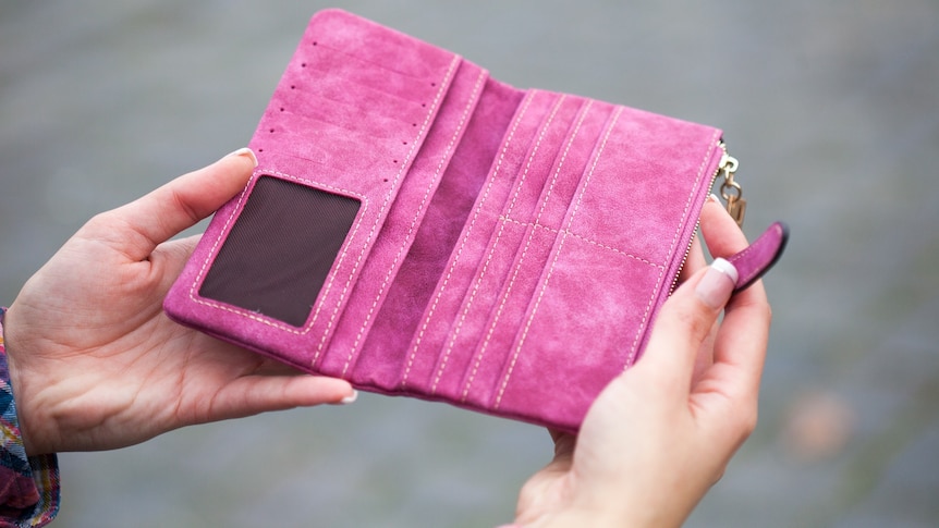 Woman holding open an empty pink wallet