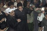 Asif Ali Zardari (with white cap) and Bilawal leave after Benazir Bhutto's funeral, December 28, 2007.