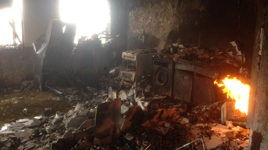 An image shows fire still burning in Grenfell tower, a blackened oven and stove are also visible.