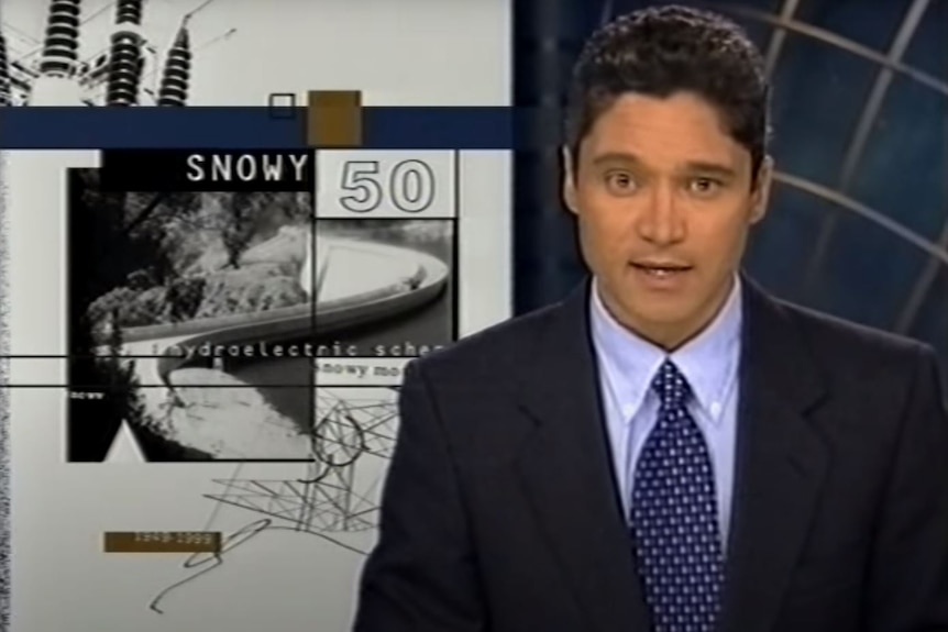 A male newsreader wearing a shirt and tie.