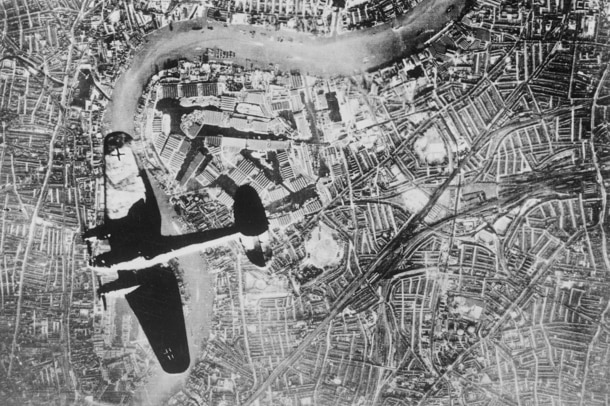 An aerial shot of a plane flying over a city.