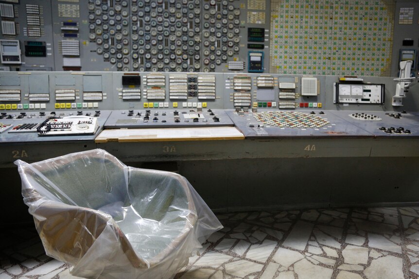 Plastic over a chair in what appears to be a control room at a nuclear plant
