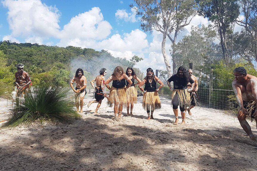 Women in centre of  traditional owners the Butchulla peoples' celebratory dance in traditional costume on Fraser Island.
