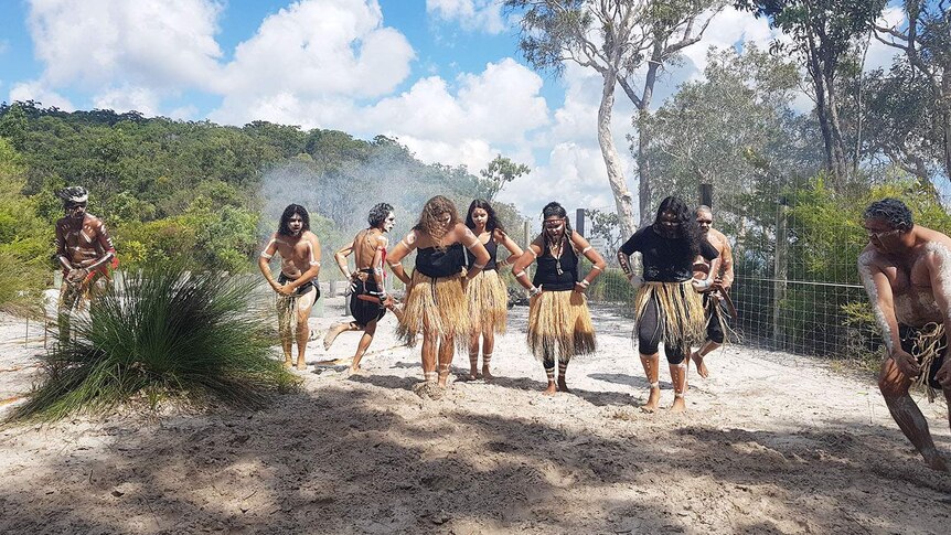 Women in centre of  traditional owners the Butchulla peoples' celebratory dance in traditional costume on Fraser Island.